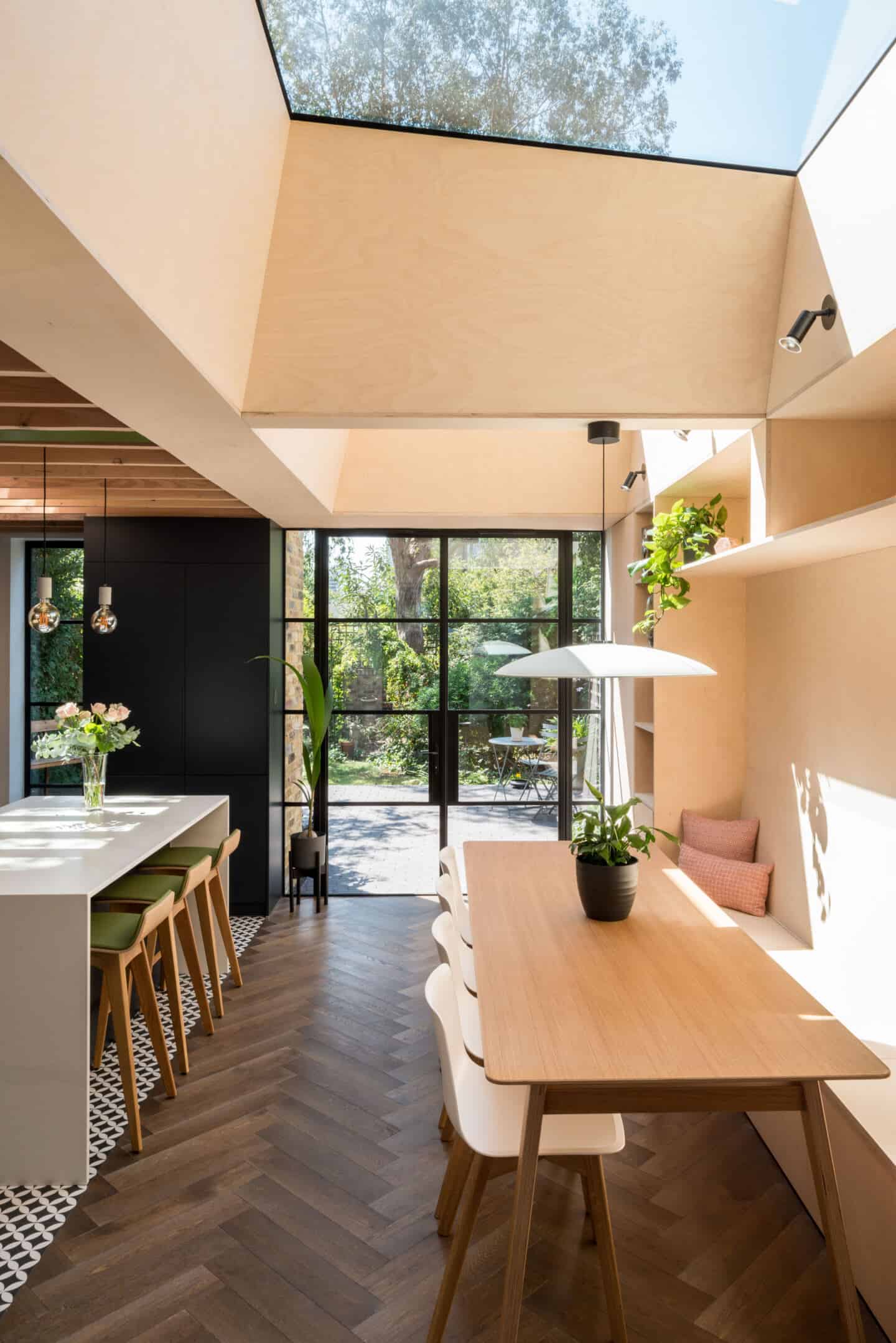 Natural light flows into this dining area from glass doors and a roof light