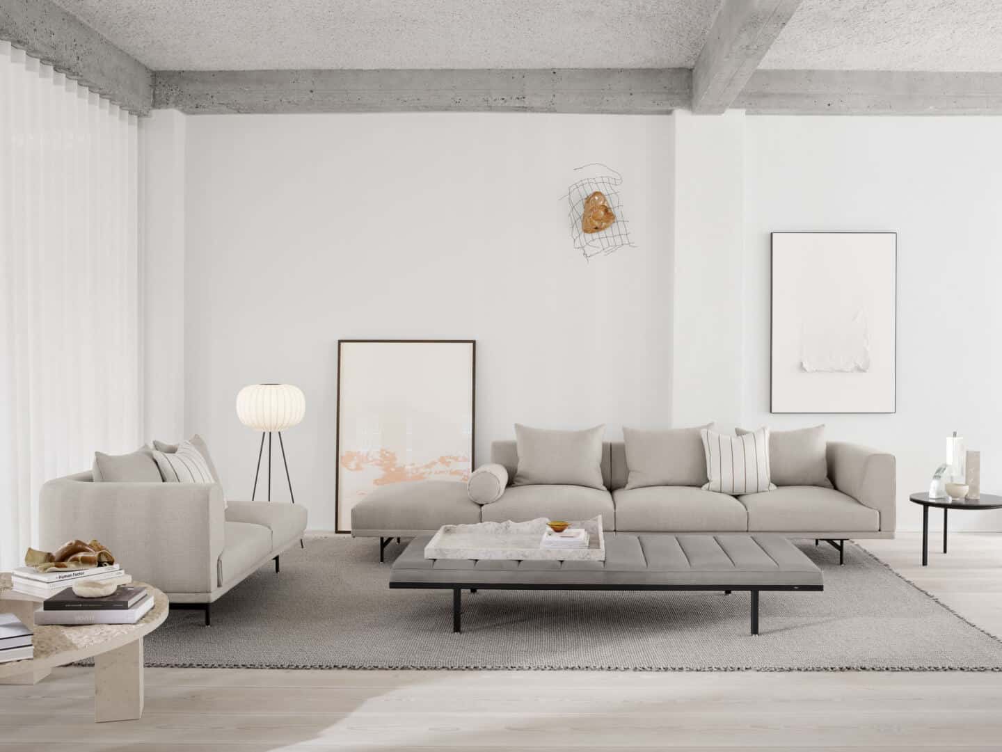 Japandi living room featuring low grey sofas and a low grey coffee table with a floor-standing paper light from Vipp