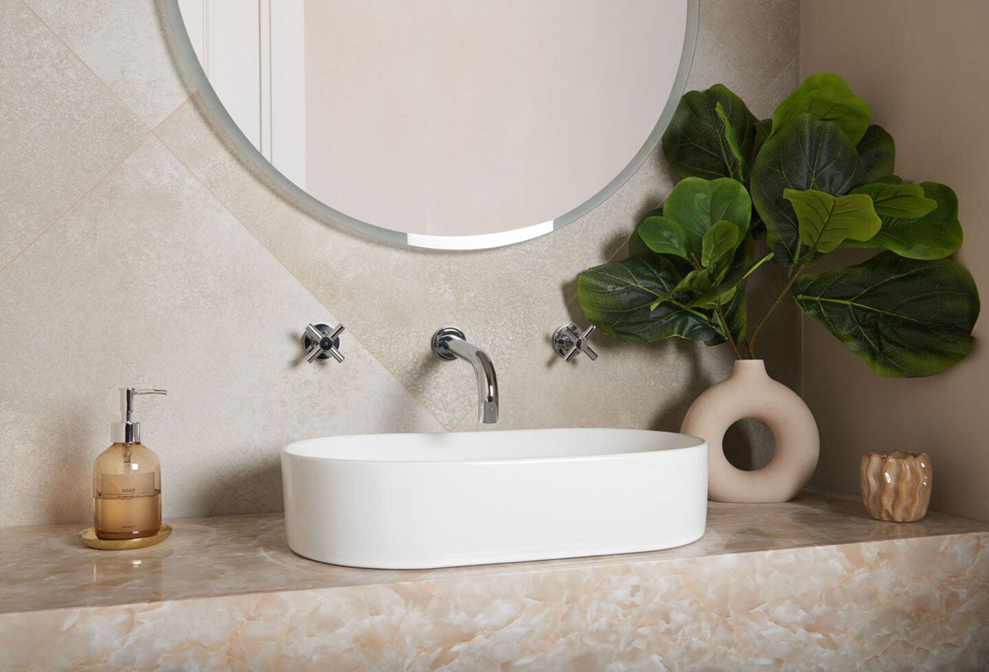 A bathroom sink with mirror above on a tiled wall and 