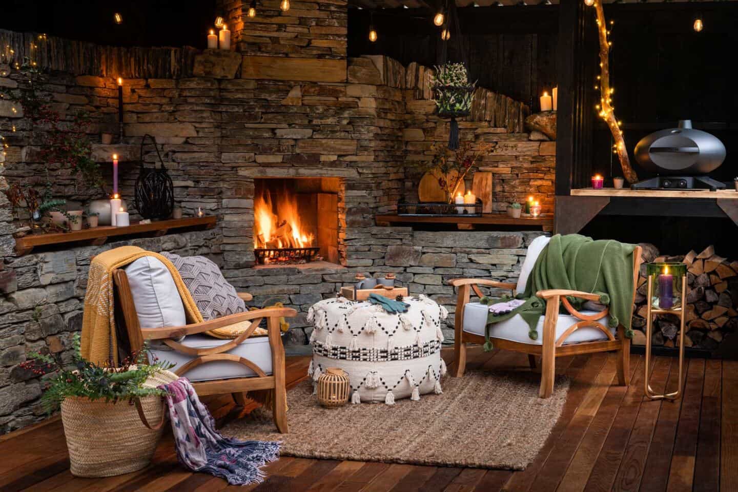 The covered outdoor dining area at the Wildwood Spa in the forest of North devon features cosy seats and blankets, fairy lights, a fireplace and a Morso BBQ