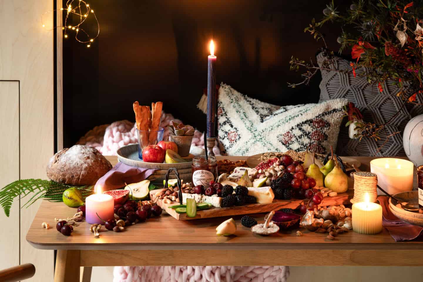 A wooden table at Wildwood Spa covered in fresh fruits, cheeses, cured meats, nuts and bread