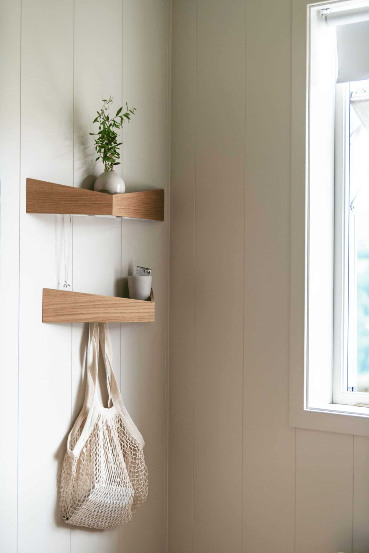 Small triangular wooden shelves with hooks beneath