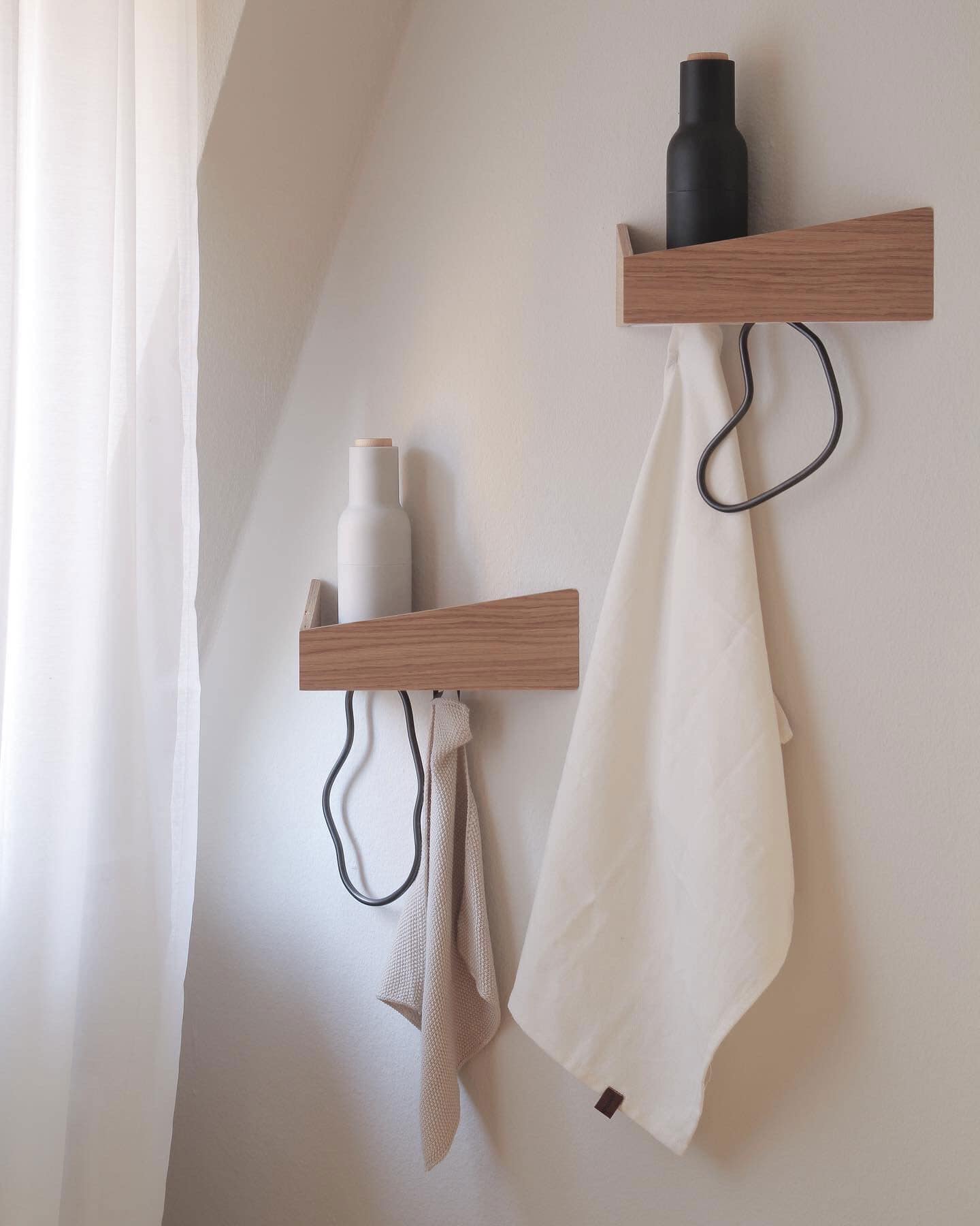 Small triangular wooden shelves with hooks beneath