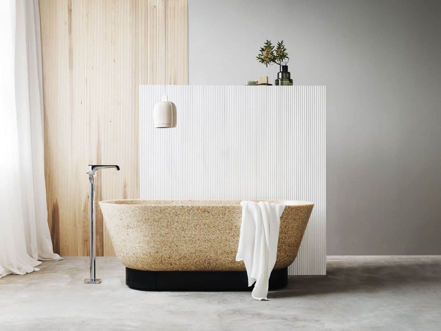 Woodio Wood Composite Sanitaryware. A freestanding bathtub made from woodchips with a towel draped over