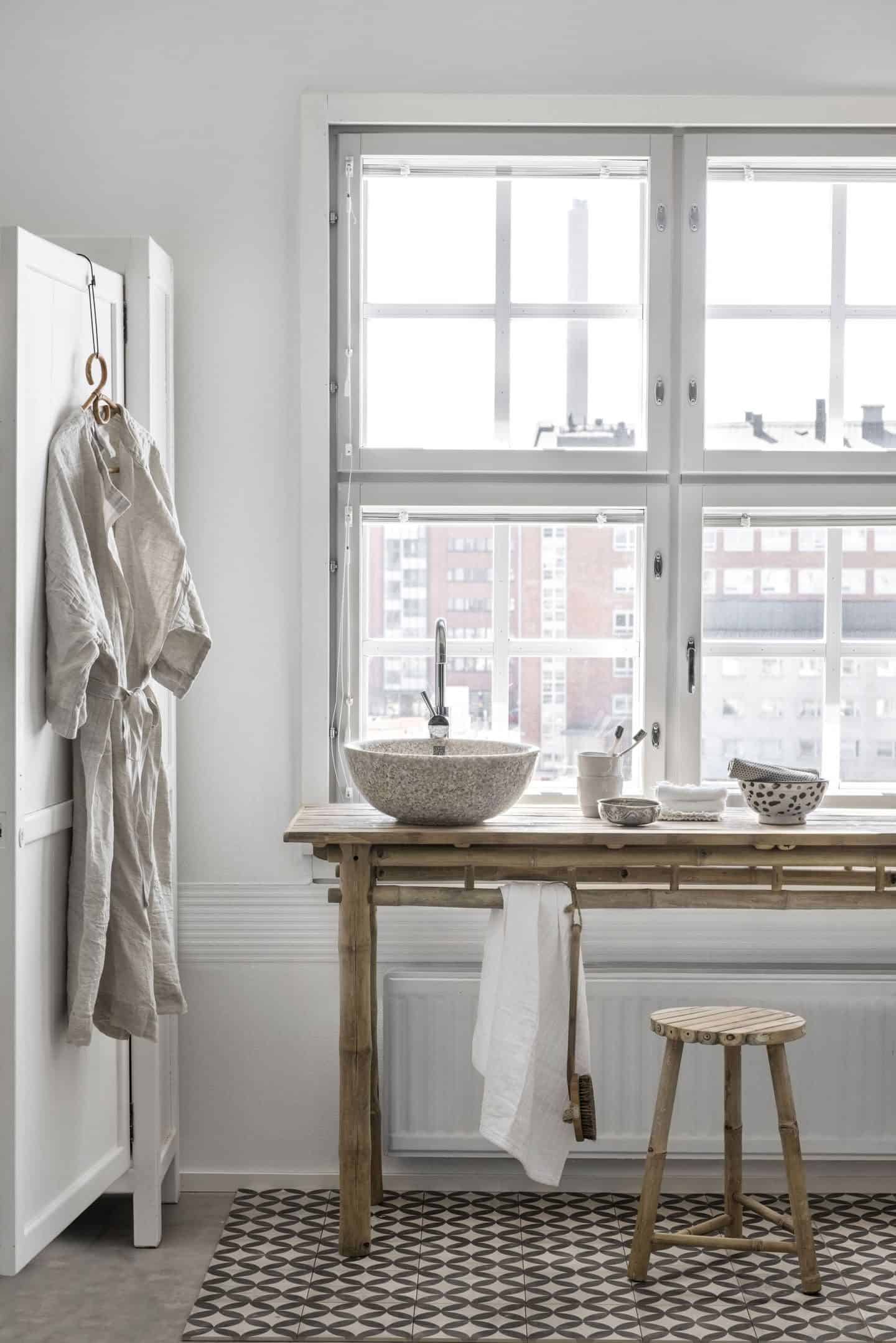 Woodio Wood Composite Sanitaryware. A small round bathroom basin made from wood chips sits atop a wooden table made from bamboo poles.