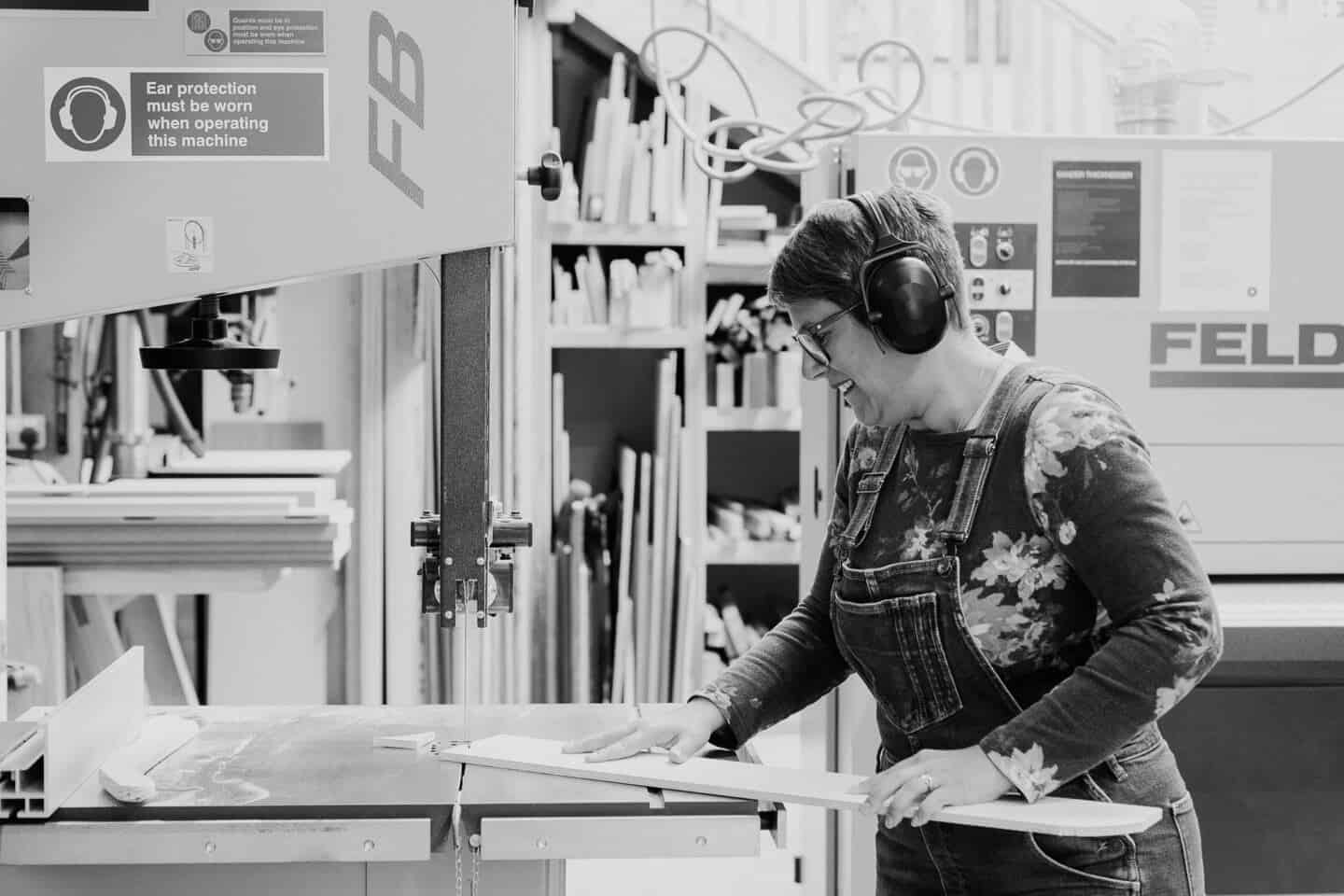 A woman using a band saw on a woodwork course at the Woodlab in Devon