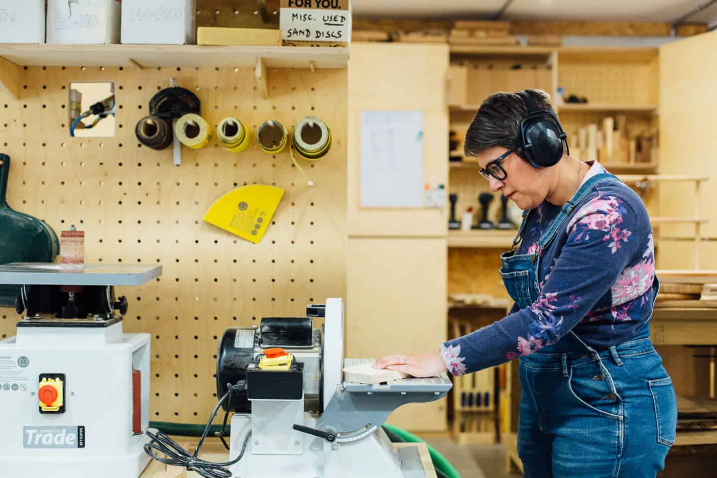 A woman using an oscillating sander on a woodwork course at the Woodlab in Devon