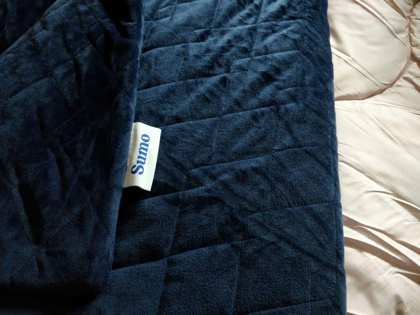 World Sleep Day 2020-5 Ways to Improve your Sleep. A coverless pink duvet and navy blue weighted blanket on a bed