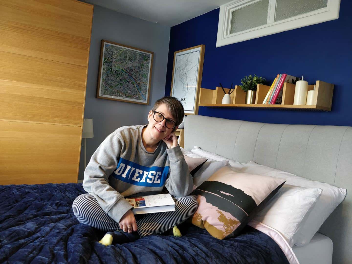 World Sleep Day 2020-5 Ways to Improve your Sleep. Woman sitting on a bed with a book.