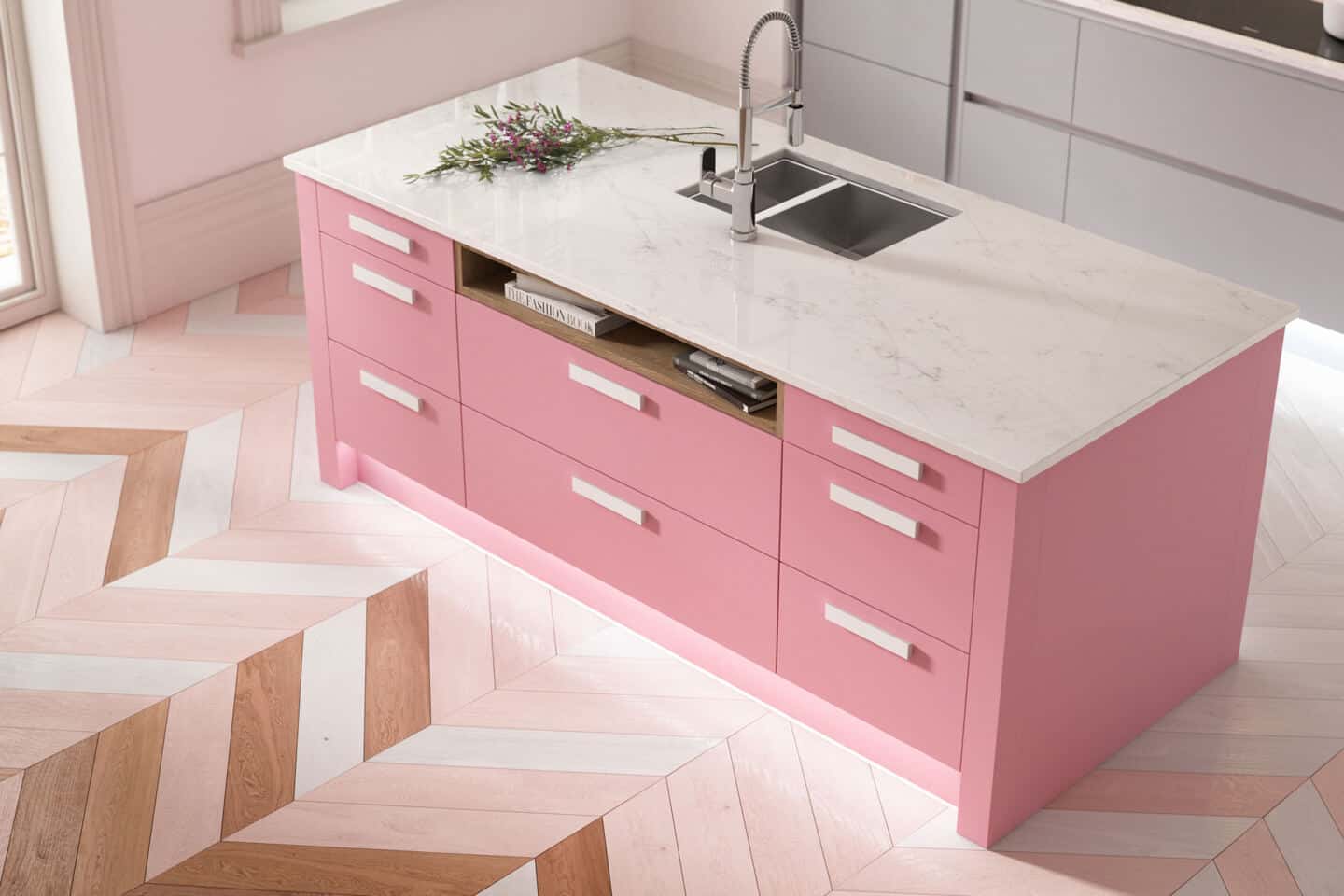 A baby pink kitchen island with marble work top  and herringbone floor